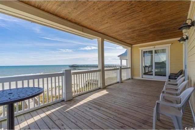 deck with a view of the beach and a water view