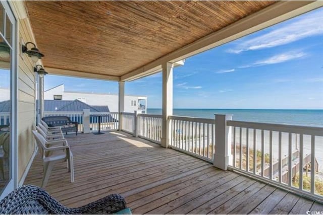 deck with a water view and a view of the beach