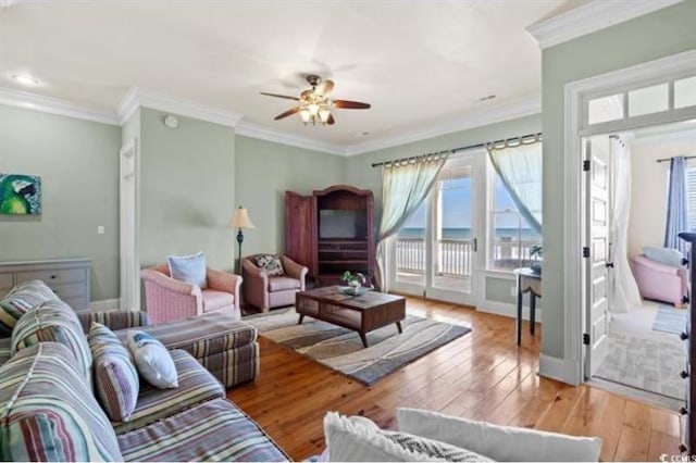 living room with light hardwood / wood-style floors, crown molding, and ceiling fan