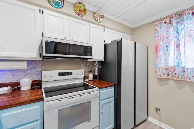 kitchen with stainless steel fridge, tasteful backsplash, wooden counters, white cabinets, and white electric range