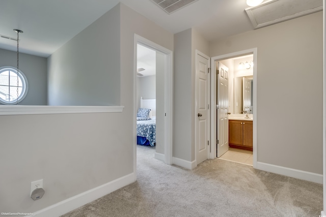 corridor with sink and light colored carpet