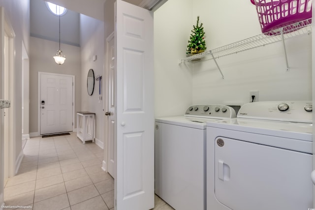 clothes washing area with washer and dryer and light tile patterned floors