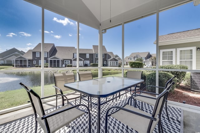 sunroom featuring a water view