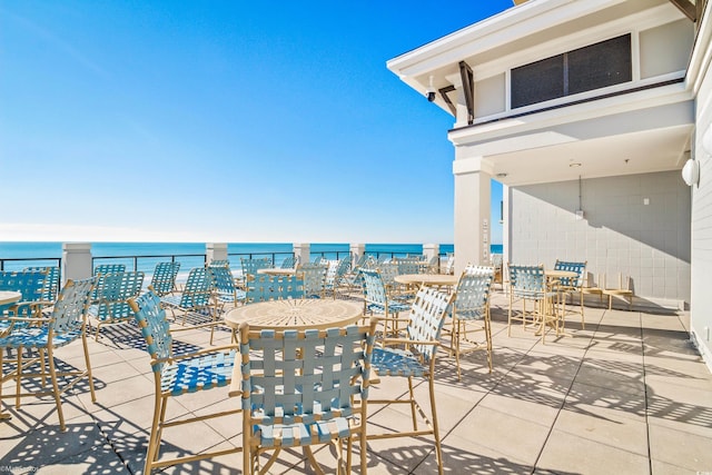 view of patio with a water view and a balcony