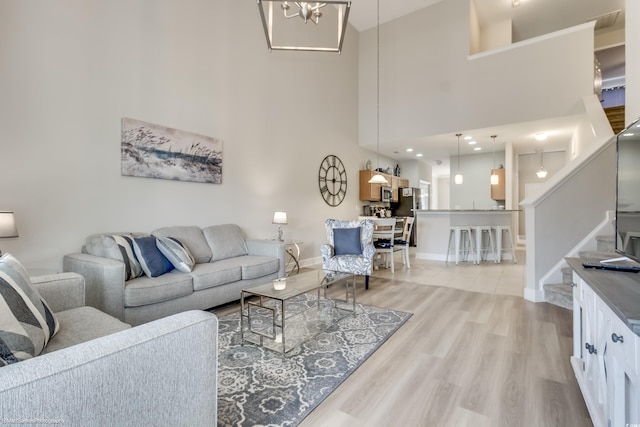 living room featuring a high ceiling and light wood-type flooring