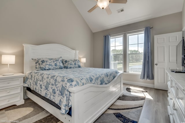 bedroom with ceiling fan, lofted ceiling, and hardwood / wood-style floors