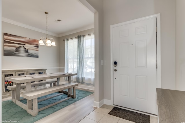 tiled dining area with crown molding and a chandelier