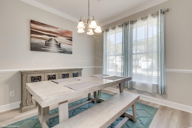 dining area with ornamental molding, a chandelier, and light wood-type flooring