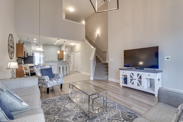 living room featuring light wood-type flooring and a towering ceiling