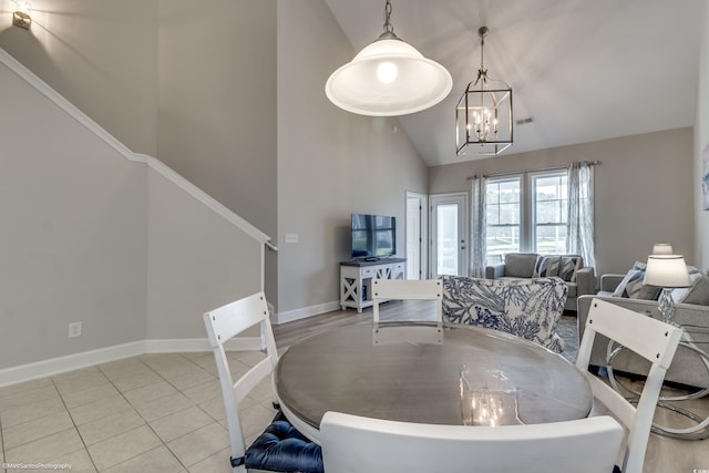 tiled dining area featuring lofted ceiling and a notable chandelier