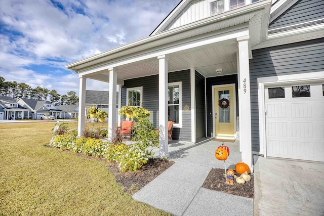 doorway to property featuring a yard, covered porch, and a garage