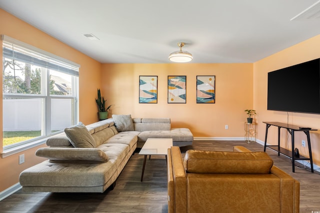 living room with dark hardwood / wood-style flooring and a healthy amount of sunlight