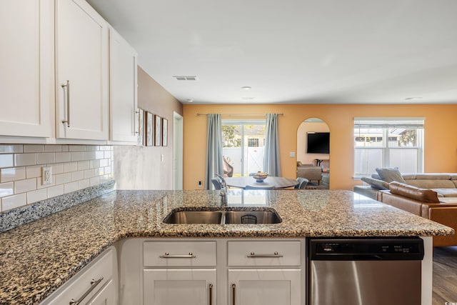 kitchen featuring sink, light stone countertops, stainless steel dishwasher, hardwood / wood-style floors, and white cabinets