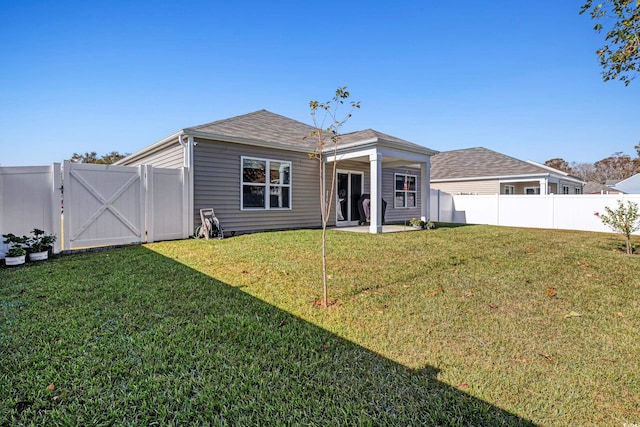 back of property with a lawn and a patio area