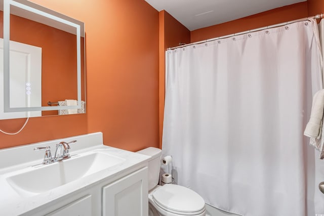 bathroom featuring toilet, vanity, and a shower with shower curtain