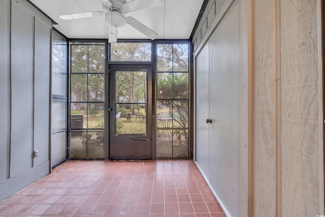 unfurnished sunroom with ceiling fan