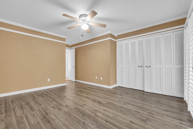 unfurnished bedroom featuring a textured ceiling, hardwood / wood-style flooring, ceiling fan, and ornamental molding