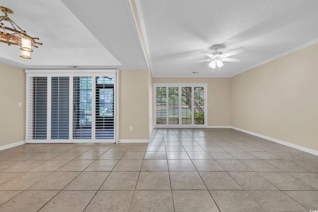 tiled empty room featuring a textured ceiling, ceiling fan, and ornamental molding