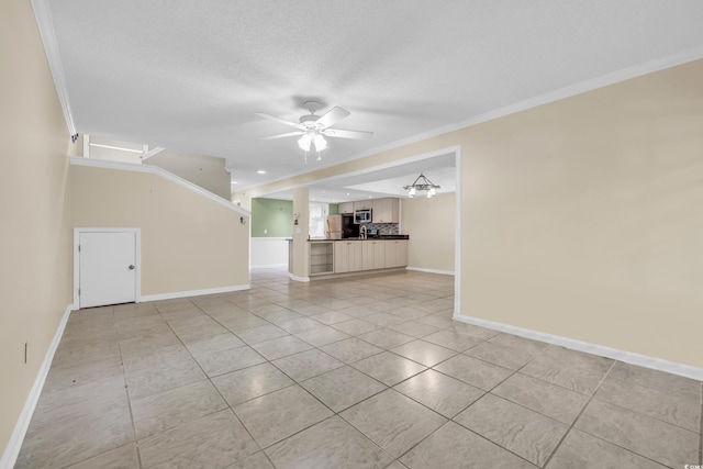 unfurnished living room with a textured ceiling, light tile patterned flooring, ceiling fan with notable chandelier, and ornamental molding