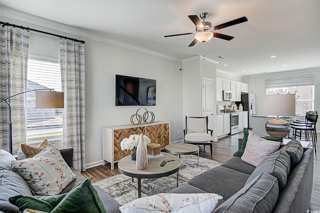 living room featuring ceiling fan, a wealth of natural light, and dark hardwood / wood-style floors