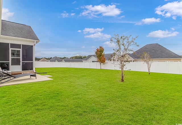 view of yard with a sunroom and a patio area