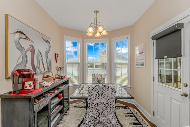 dining space featuring hardwood / wood-style flooring, a wealth of natural light, and a notable chandelier