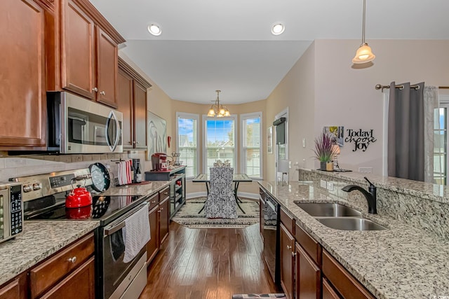 kitchen featuring dark hardwood / wood-style flooring, an inviting chandelier, sink, appliances with stainless steel finishes, and decorative light fixtures