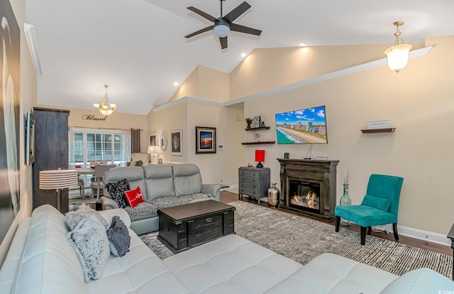 living room featuring light wood-type flooring, ceiling fan with notable chandelier, and high vaulted ceiling