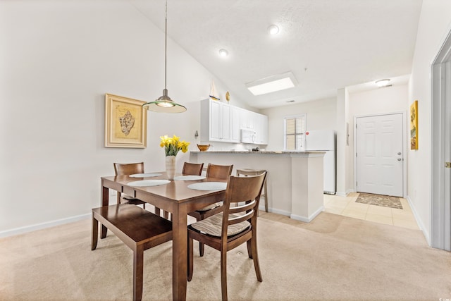 carpeted dining room with a textured ceiling and high vaulted ceiling