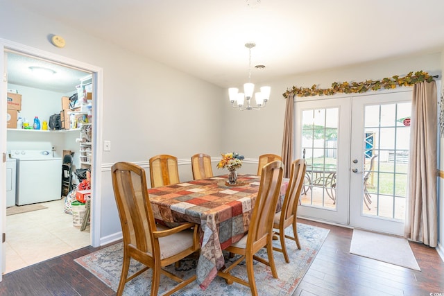 dining room with french doors, independent washer and dryer, hardwood / wood-style flooring, and an inviting chandelier