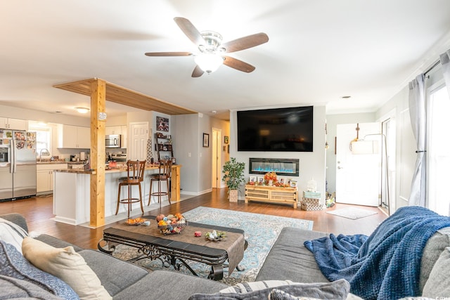 living room with hardwood / wood-style floors, sink, and ceiling fan