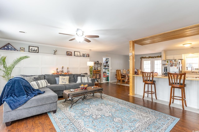 living room with ceiling fan, crown molding, sink, and dark hardwood / wood-style floors