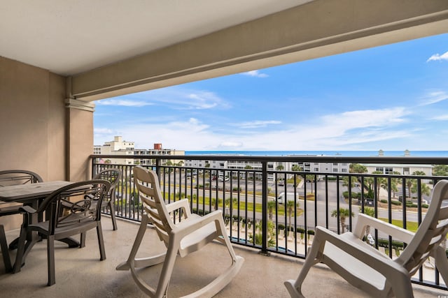 balcony featuring a view of the beach and a water view