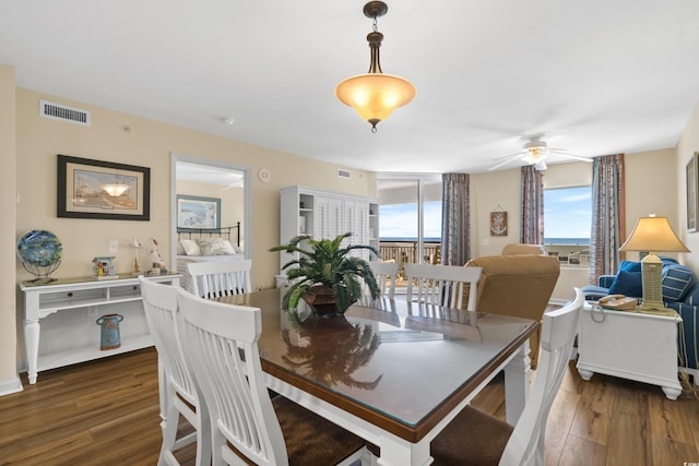 dining area featuring wood finished floors, a ceiling fan, and visible vents