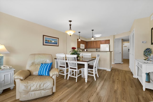 dining room with light wood-style flooring and baseboards