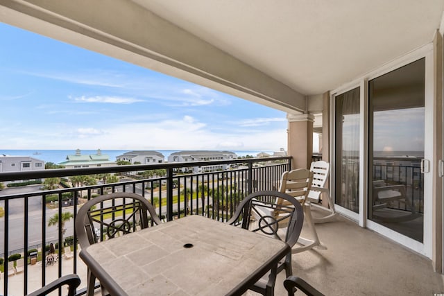 balcony featuring a water view and outdoor dining space