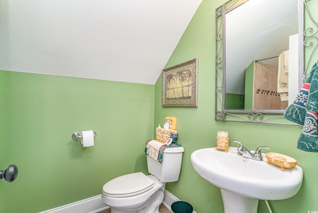 bathroom with sink, toilet, and vaulted ceiling