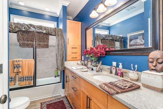 full bathroom with toilet, a healthy amount of sunlight, ornamental molding, vanity, and combined bath / shower with glass door