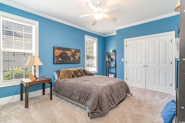 carpeted bedroom with crown molding, a closet, and ceiling fan