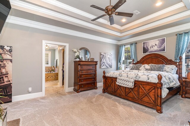 bedroom with connected bathroom, light carpet, crown molding, a raised ceiling, and ceiling fan