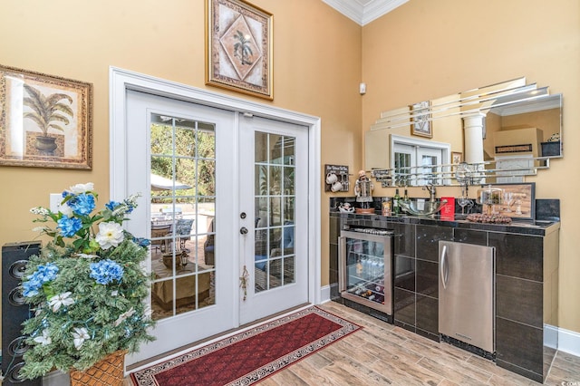 doorway to outside with ornamental molding, french doors, and wood-type flooring