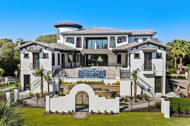 rear view of house featuring a lawn and a balcony