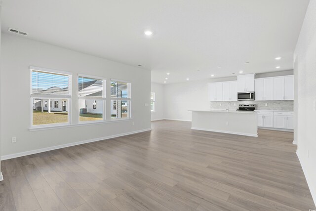 unfurnished living room with light wood-type flooring and sink