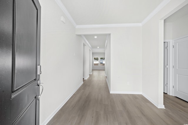 hall with light hardwood / wood-style flooring and crown molding