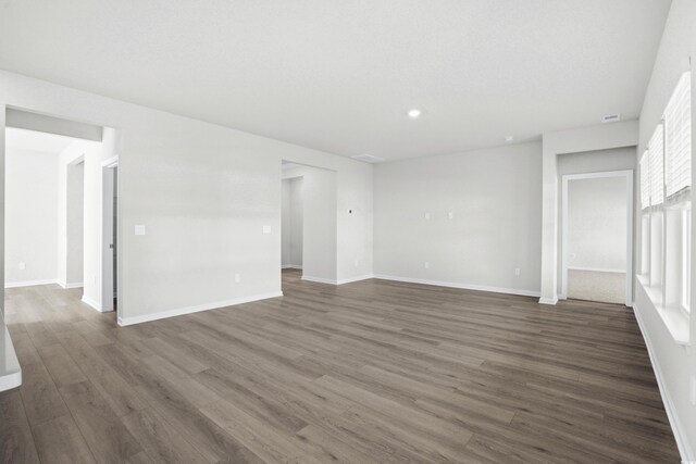 unfurnished room with dark wood-type flooring