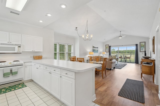 kitchen with lofted ceiling, kitchen peninsula, light wood-type flooring, white cabinetry, and white appliances