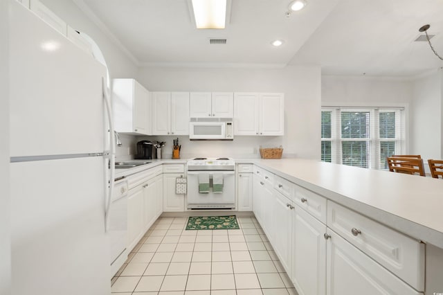 kitchen with white appliances, ornamental molding, kitchen peninsula, and white cabinets