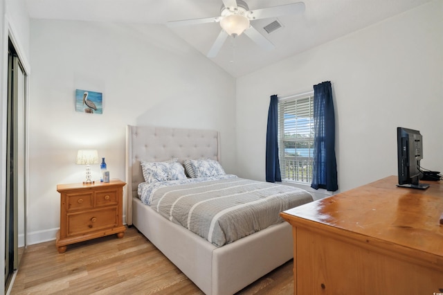 bedroom with a closet, vaulted ceiling, light wood-type flooring, and ceiling fan