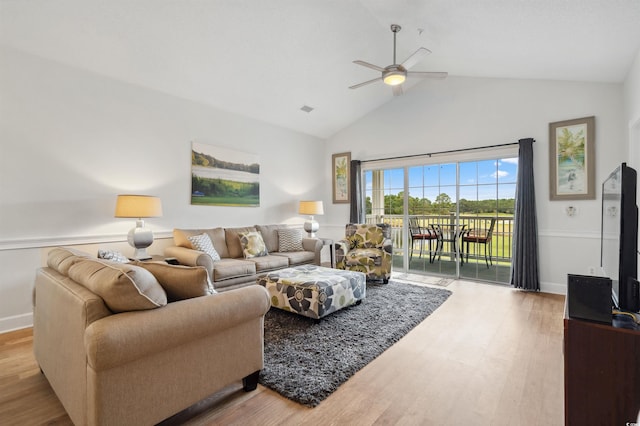 living room with ceiling fan, vaulted ceiling, and light wood-type flooring