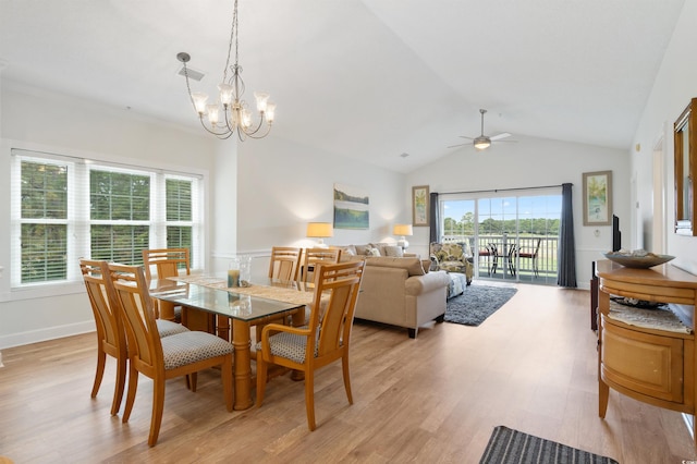 dining space with lofted ceiling, ceiling fan with notable chandelier, and light hardwood / wood-style floors